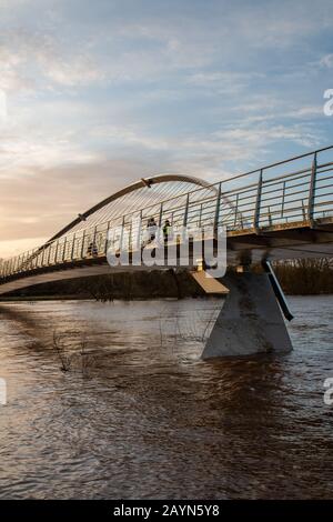 Wetter in Großbritannien. Pendler gehen über die Millennium Bridge am überfluteten Fluss Ouse in York vorbei. Stockfoto