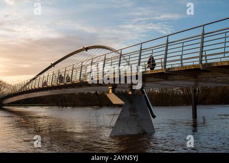 Wetter in Großbritannien. Pendler gehen über die Millennium Bridge am überfluteten Fluss Ouse in York vorbei. Stockfoto