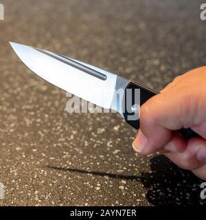 Symbole, Symbolbild, Eine Faust haelt ein Messer in der Hand. Stockfoto