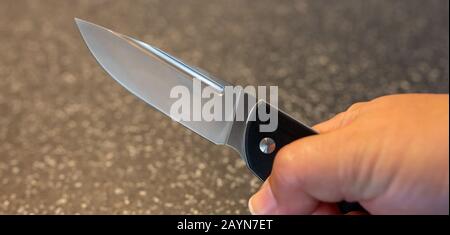 Symbole, Symbolbild, Eine Faust haelt ein Messer in der Hand. Stockfoto