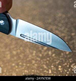 Symbole, Symbolbild, Eine Faust haelt ein Messer in der Hand. Stockfoto