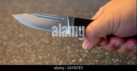 Symbole, Symbolbild, Eine Faust haelt ein Messer in der Hand. Stockfoto