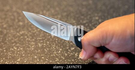 Symbole, Symbolbild, Eine Faust haelt ein Messer in der Hand. Stockfoto