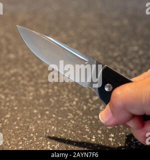 Symbole, Symbolbild, Eine Faust haelt ein Messer in der Hand. Stockfoto