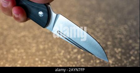 Symbole, Symbolbild, Eine Faust haelt ein Messer in der Hand. Stockfoto