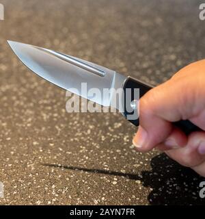Symbole, Symbolbild, Eine Faust haelt ein Messer in der Hand. Stockfoto