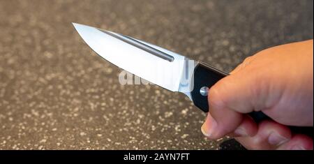 Symbole, Symbolbild, Eine Faust haelt ein Messer in der Hand. Stockfoto