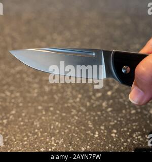 Symbole, Symbolbild, Eine Faust haelt ein Messer in der Hand. Stockfoto