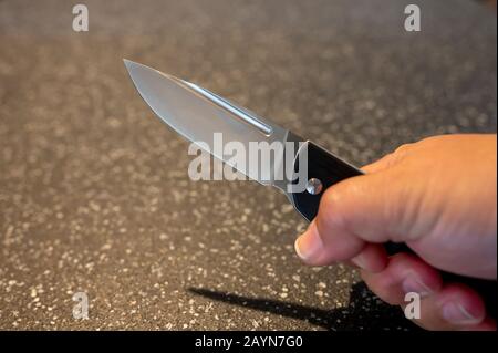 Symbole, Symbolbild, Eine Faust haelt ein Messer in der Hand. Stockfoto