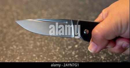 Symbole, Symbolbild, Eine Faust haelt ein Messer in der Hand. Stockfoto