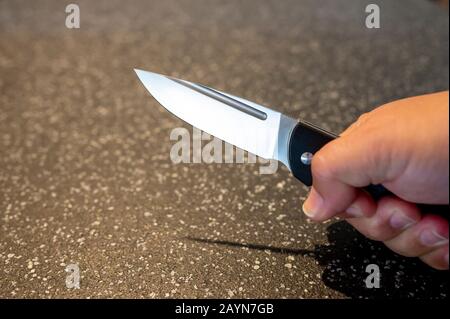 Symbole, Symbolbild, Eine Faust haelt ein Messer in der Hand. Stockfoto