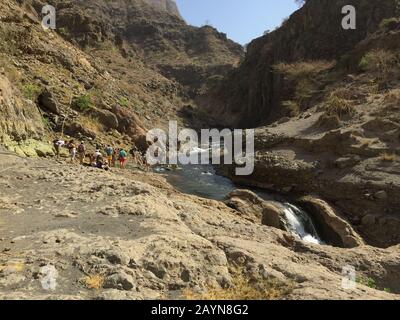 NGARE-SERO. Tansania - 20. AUGUST 2019: Der Touristen amd Maasai geht am Fluss Ngare Sero in der Nähe des Natron-Sees in Tansania, Afrika Stockfoto