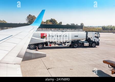 Pisa, ITALIEN - 14. Oktober 2018: Kerosin-LKW in der Nähe des Flugzeugs auf der Start- und Landebahn des Flughafens Stockfoto