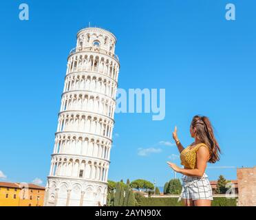 Pisa, ITALIEN - 14. Oktober 2018: Touristenfrau posiert mit Schiefer Turm für instagram-foto während der Reise in Pisa Stockfoto