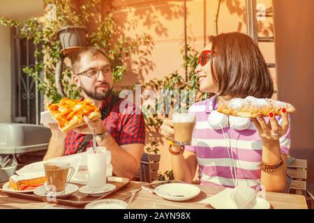 Fröhliche Freunde, die in einem Café speisen, mit Focaccia und Croissant mit Kaffee. Konzept für Lebensmittel und Beziehungen Stockfoto