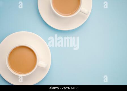 Zwei weiße Tassen Kaffee mit Milch, hellblauer Hintergrund, Draufsicht. Americano. Kopierbereich Stockfoto