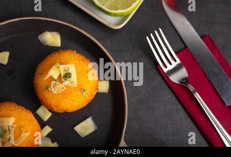 Hausgemachte Kroketten, gefüllt mit Käse mit Zitrone und einem Glas Rotwein. Stockfoto