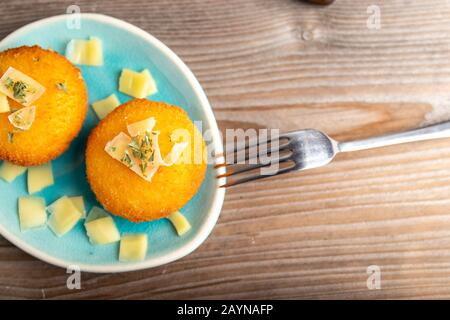 Hausgemachte Kroketten, gefüllt mit Käse mit Zitrone und einem Glas Rotwein. Stockfoto