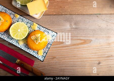 Hausgemachte Kroketten, gefüllt mit Käse mit Zitrone und einem Glas Rotwein. Stockfoto