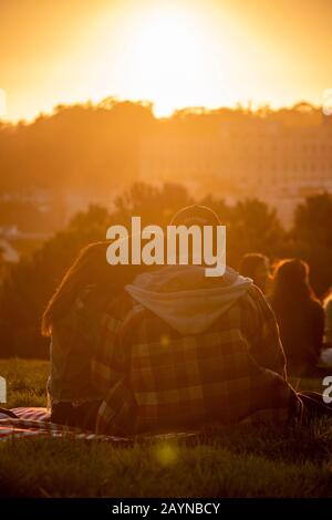 Paare beobachten den Sonnenuntergang vom Alamo Square Park in San Francisco, Kalifornien. Stockfoto