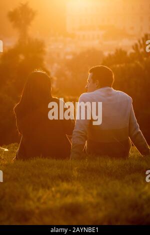 Paare beobachten den Sonnenuntergang vom Alamo Square Park in San Francisco, Kalifornien. Stockfoto