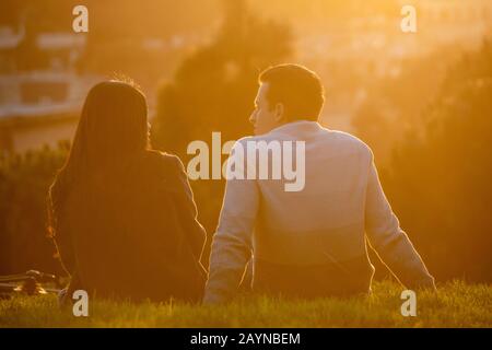 Paare beobachten den Sonnenuntergang vom Alamo Square Park in San Francisco, Kalifornien. Stockfoto