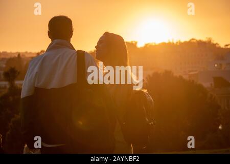 Paare beobachten den Sonnenuntergang vom Alamo Square Park in San Francisco, Kalifornien. Stockfoto