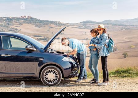 Eine Gruppe von Freunden, die Probleme mit dem kaputten Auto haben, während sie mit dem Mietwagen in der Toskana reisen Stockfoto