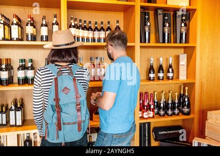 18. OKTOBER 2018, TOSKANA, ITALIEN: Freunde kaufen Luxuswein im Spezialgeschäft ein Stockfoto