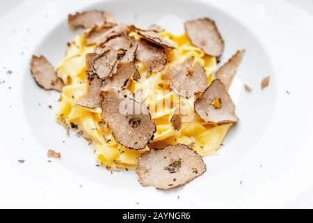 Köstliche italienische Pasta mit Trüffelpilzchips auf dem Tisch im Luxus-Restaurant. Stockfoto