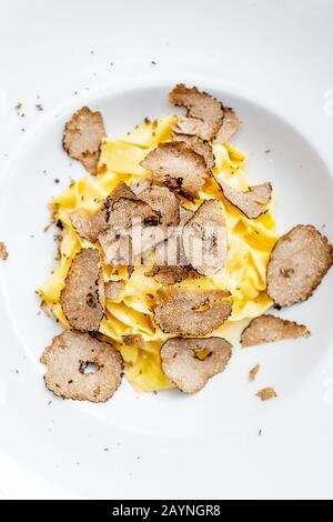 Köstliche italienische Pasta mit Trüffelpilzchips auf dem Tisch im Luxus-Restaurant. Stockfoto