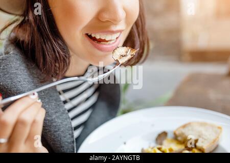 Glückliche asianerin, die Pasta mit Trüffel im italienischen Restaurant im Freien isst Stockfoto
