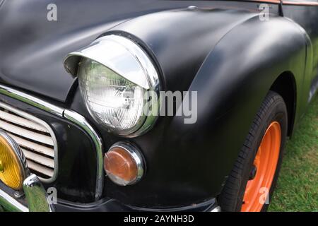 Schwarze und orangefarbene Vorderseite von Oldtimern auf dem Gras Stockfoto