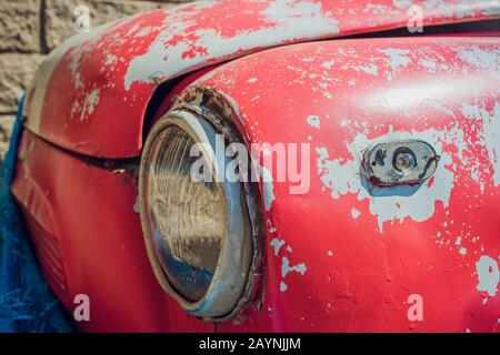 Detail des vorderen Scheinwerfers eines alten Wagens in der Garage Stockfoto