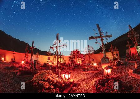 21. OKTOBER 2018, SANTA MAGDALENA, ITALIEN: Kirchhof nachts unter Sternen mit roten Laternen Stockfoto