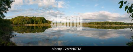 Wunderschönes Panorama auf den Herbstsee vor dem Hintergrund von Wald und sonnigem Himmel Stockfoto