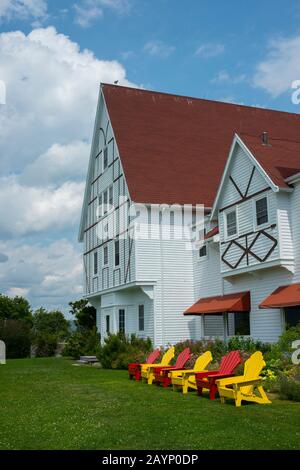 Farbenfrohe Adirondack-Stühle vor dem Keltic Lodge Resort and Spa, das sich entlang des Cabot Trail auf der Kap-Breton-Insel Nova Scotia Befindet, Can Stockfoto