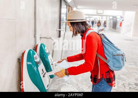 Frau validiert Ticket für modernen öffentlichen Zugverkehr Stockfoto