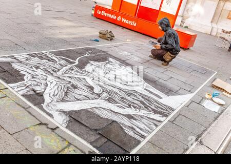 23. OKTOBER 2018, VENEDIG, ITALIEN: Ein Straßenkünstler zeichnet ein Bild auf einem Asphalt Stockfoto