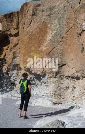 Eine Frau (Model Release 20020923-10) betrachtet Petroglyphen im Tsankawi, Bandelier National Monument in New Mexico, USA, in der Nähe von White Rock. Stockfoto