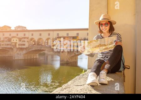 Glückliche Reisende asiaten auf einem Urlaub in Florenz bewundern die Aussicht auf die berühmte Sehenswürdigkeit Ponte Vecchio während der Reise in Italien, Europa Stockfoto