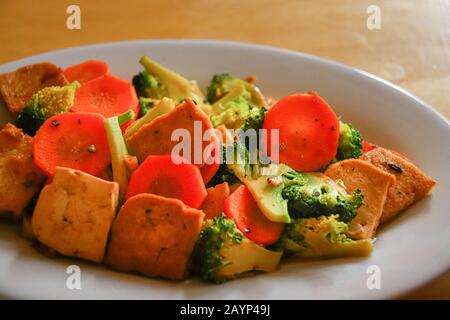 Rühren Sie gebratenen Tofu, Brokkoli und Karotten für ein gesundes veganes Mittagessen, um während der Quarantäne zu Hause gesund zu bleiben, da Covid-19 Pandemie Stockfoto
