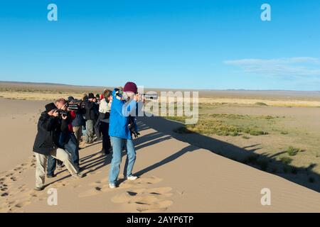 Touristen, die die Sanddünen der Hongoryn Els in der Wüste Gobi im Süden der Mongolei fotografieren. Stockfoto