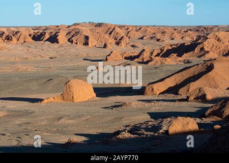 Sonnenschein am Abend auf den orangefarbenen Felsen von Bayan Zag, bekannt als Flaming Cliffs in der Wüste Gobi, der Mongolei, wo wichtige Dinosaurier-Fossilien zu finden sind Stockfoto