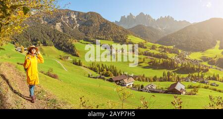 Eine glückliche asiatin, die während der Herbstsaison eine großartige Aussicht auf das Tal der Fünen in den Alpen der Alpen der Alpen in Italien genießt Stockfoto