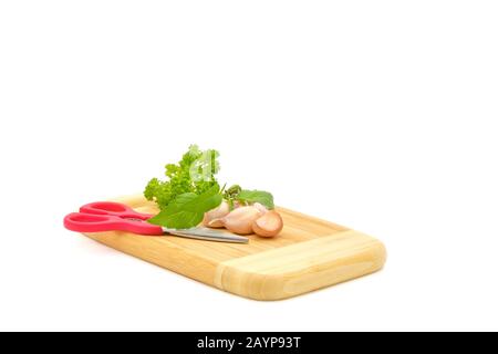 Holzschneidebrett mit mehreren Kräutern, die auf weißem Hintergrund fotografiert wurden. Stockfoto