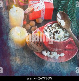 Heiße Schokolade in einem roten Becher mit Marshmallows, Keksen und Weihnachtsgeschenken im Hintergrund. Weihnachtsgetränk. Weihnachtsfeier Konzept. Stockfoto