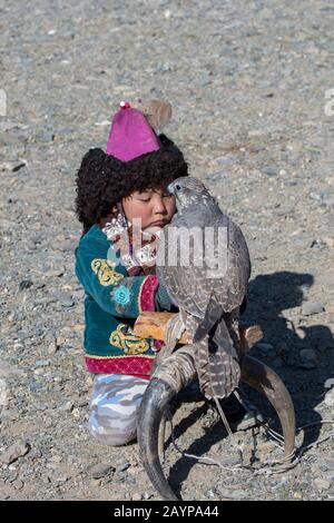 Ein Junge mit einem Sakerfalken (Falco cherrug) beim Golden Eagle Festival in der Nähe der Stadt Ulgii (Ölgii) in der Provinz Bayan-Ulgii im Westen der Mongolei. Stockfoto