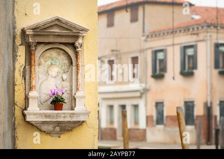 Kleiner Flügelaltar auf einem Haus in Venedig (Italien) Stockfoto