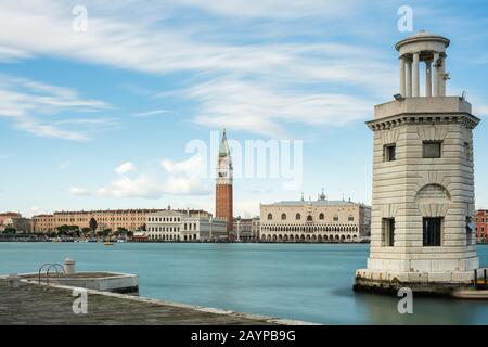 Faro San Giorgio Maggiore vor dem Campanile- und Dogenpalast in Venedig (Italien) an einem sonnigen Tag im Winter Stockfoto